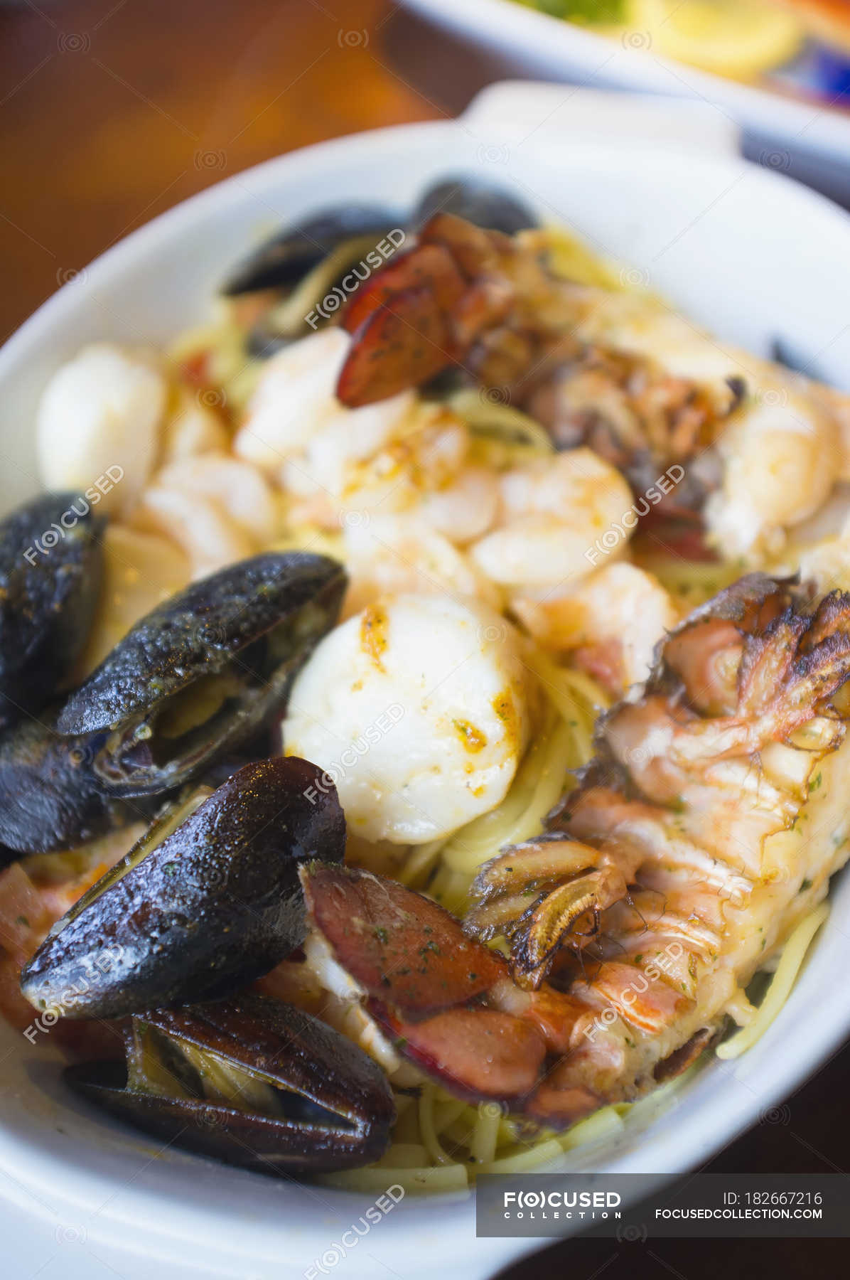 Seafood dish with lobster, mussels, scallops and pasta on plate
