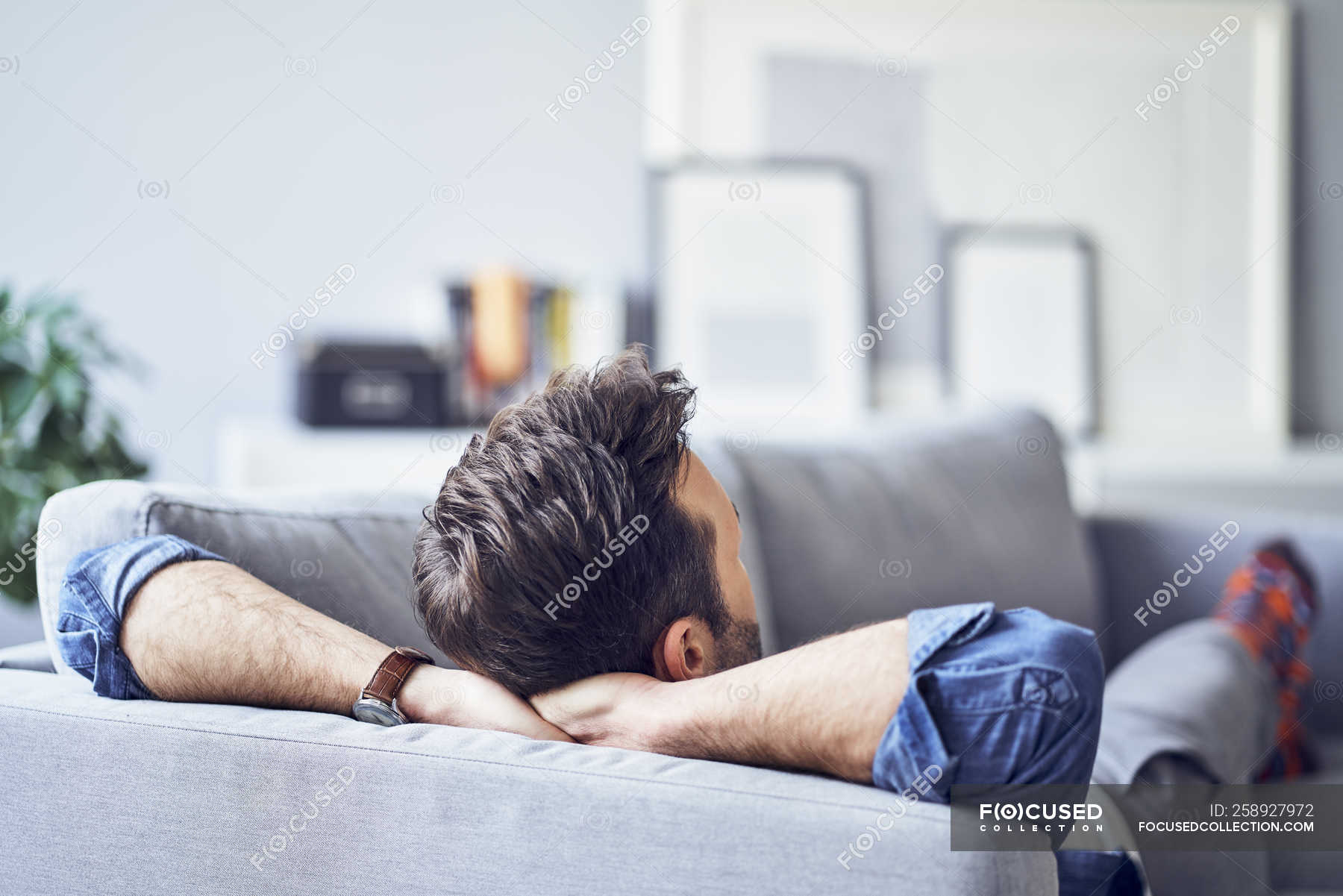Relaxed man lying on sofa — copy space, napping Stock Photo | #258927972
