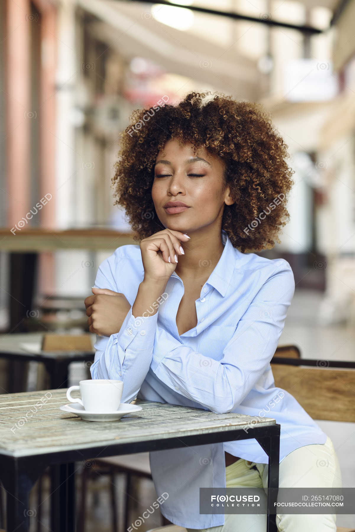 Relaxed Woman With Afro Hairstyle Sitting In Outdoor Cafe Brown