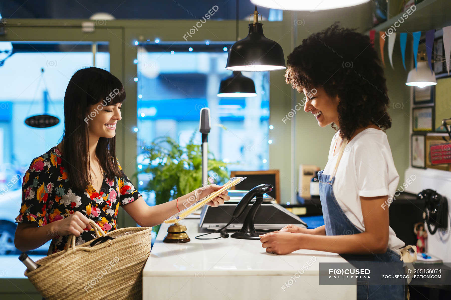 smiling-customer-and-shop-assistant-at-counter-of-a-store-female