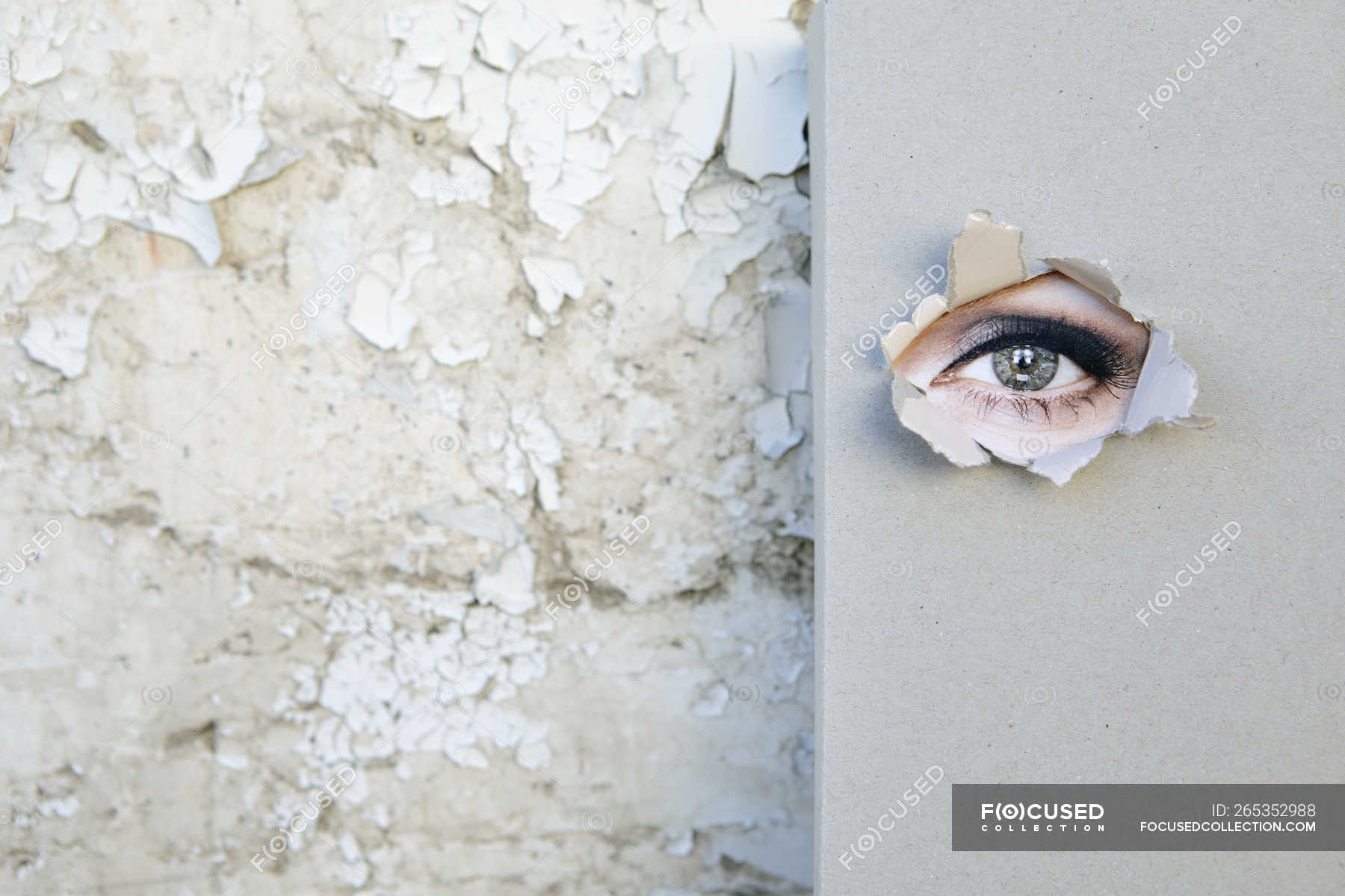 Book with eye looking through the cover leaning against weathered wall