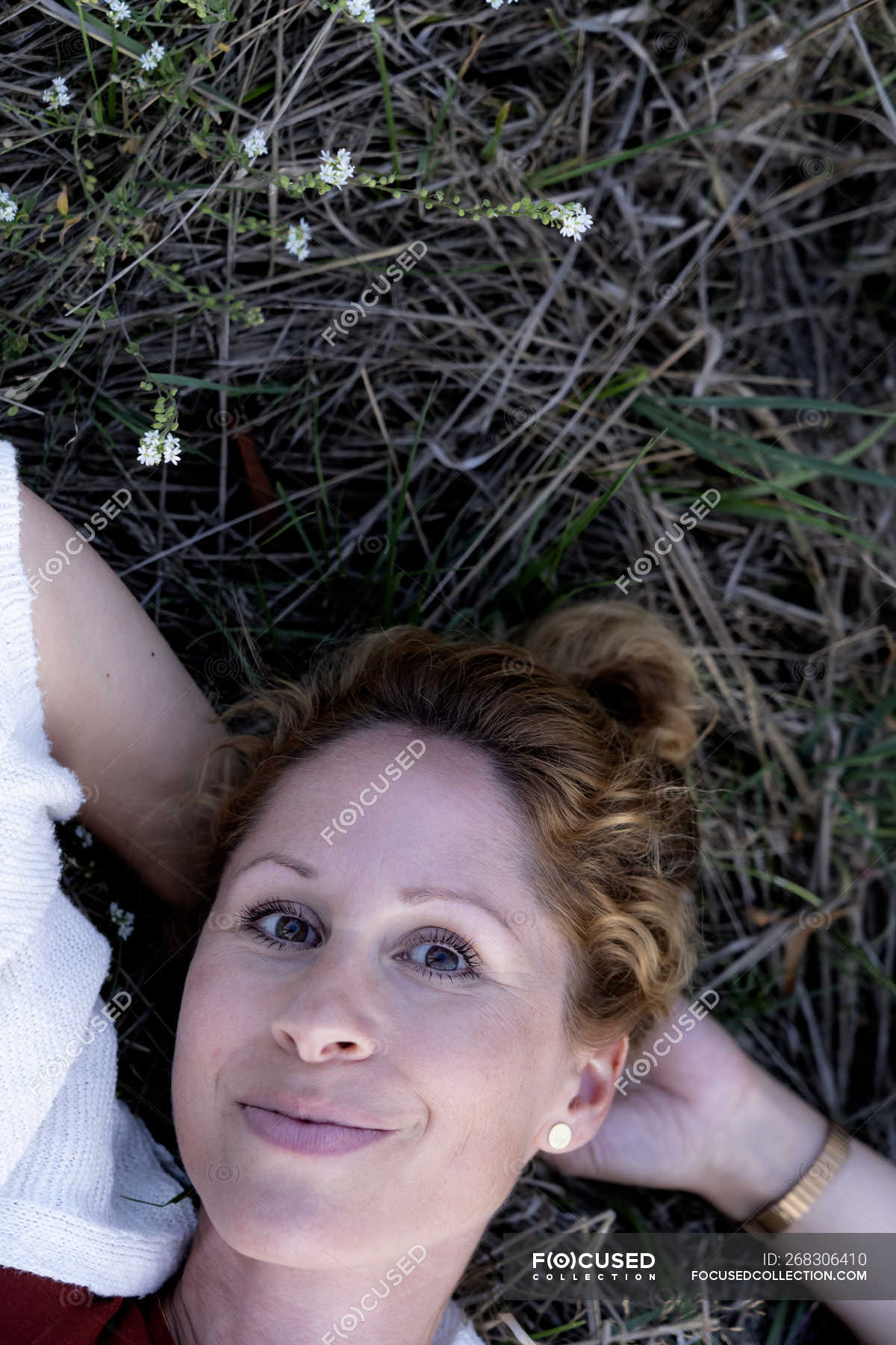 portrait-of-smiling-woman-lying-on-ground-strawberry-blonde-simple