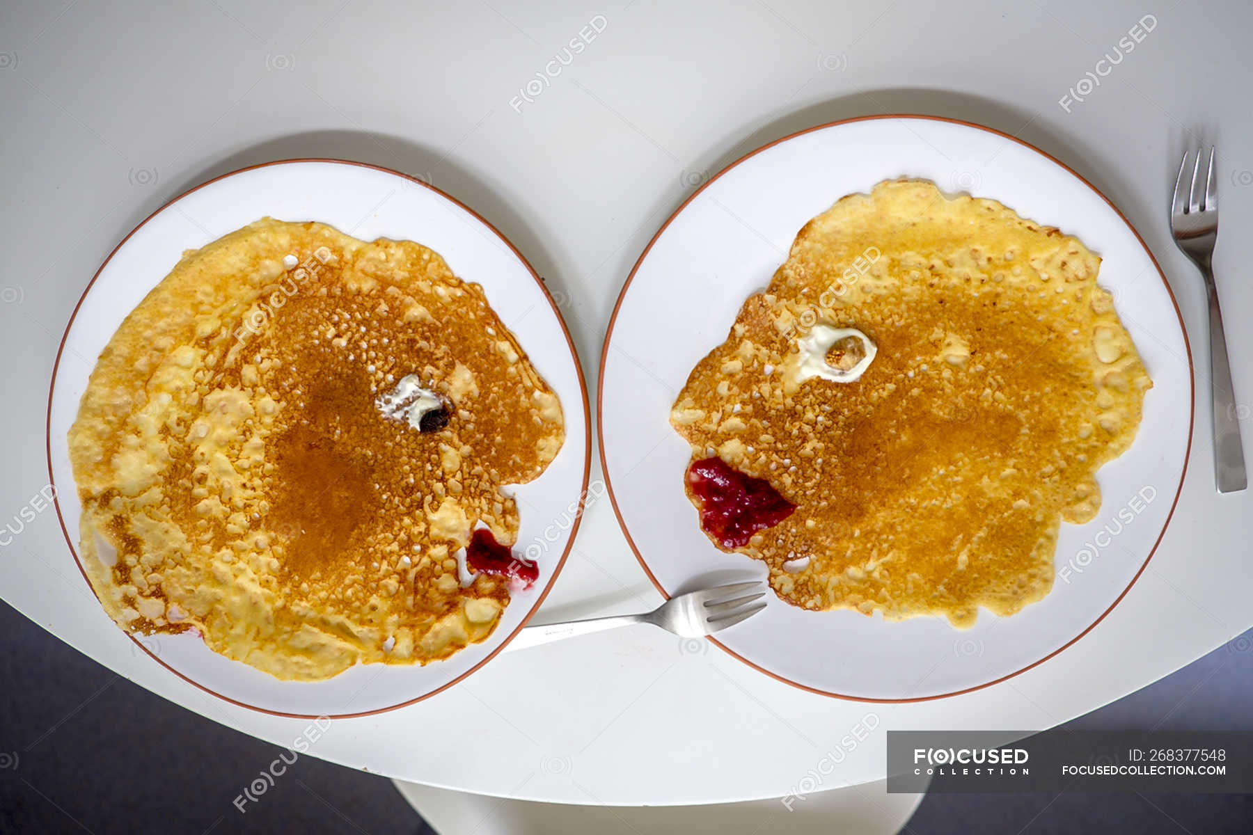 Pancakes, faces on plates, overhead — smiling, fork Stock Photo