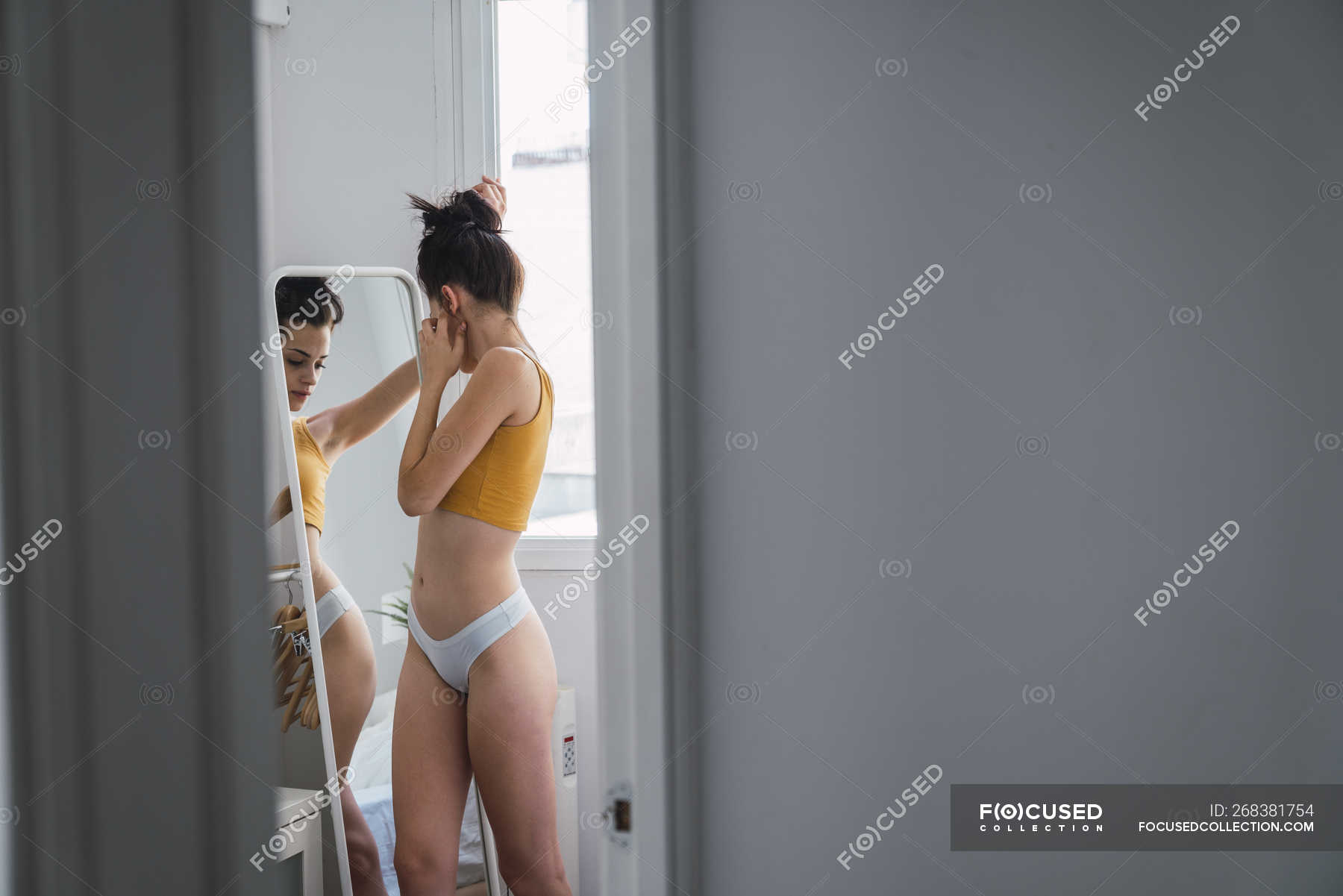 Mujer joven en ropa interior en casa el espejo — erotismo, - Stock Photo | #268381754