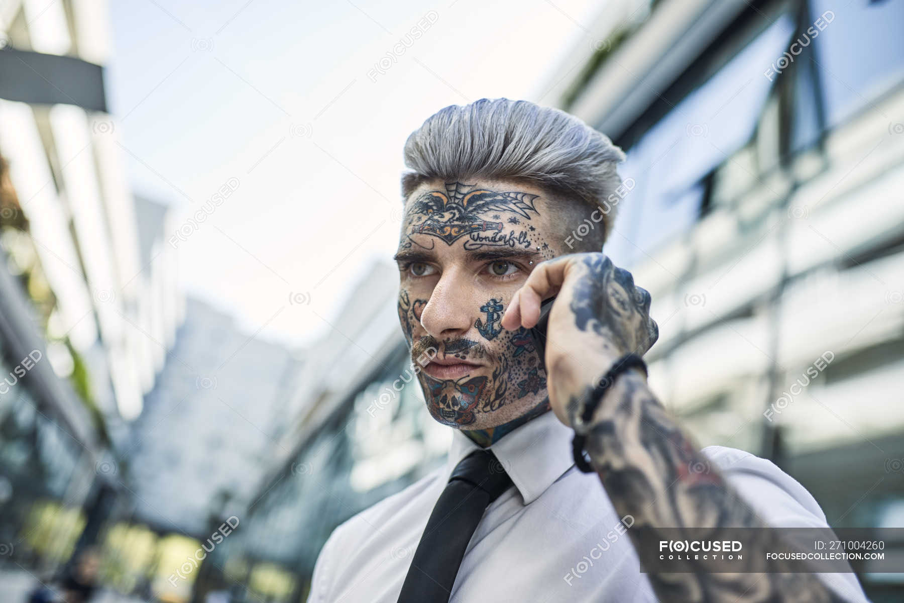 Jeune homme d'affaires au visage tatoué, parlant au téléphone — Scène  urbaine, individualité - Stock Photo | #271004260