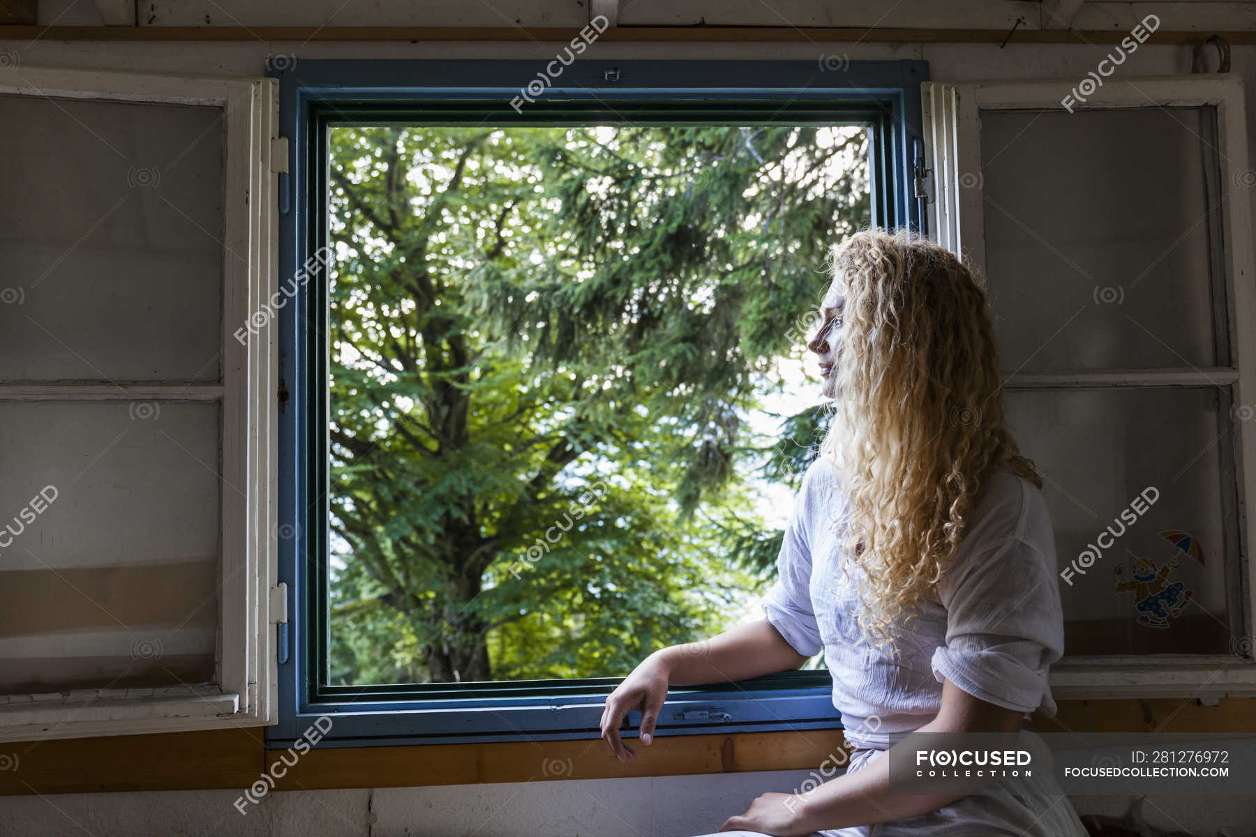 Focused 281276972 Stock Photo Young Woman Looking Out Window 
