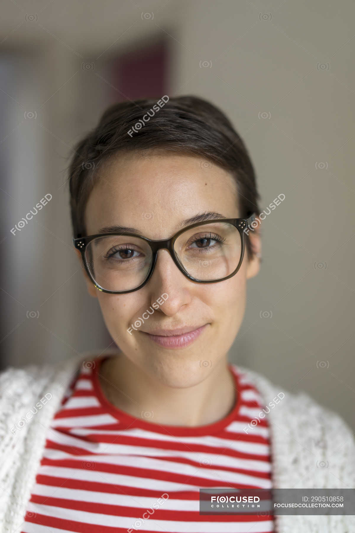 Portrait of a smiling young woman with short hair, wearing glasses — happy,  indoors - Stock Photo | #290510858