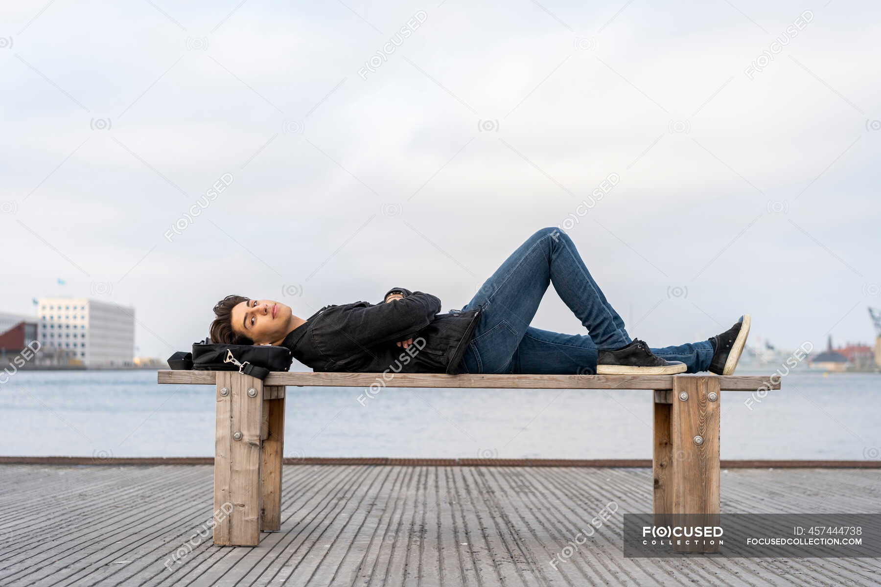 Человек лежит на камнях. Человек лежит на скамейке. Man lying on a Bench. Фото люди лежат на площадке.