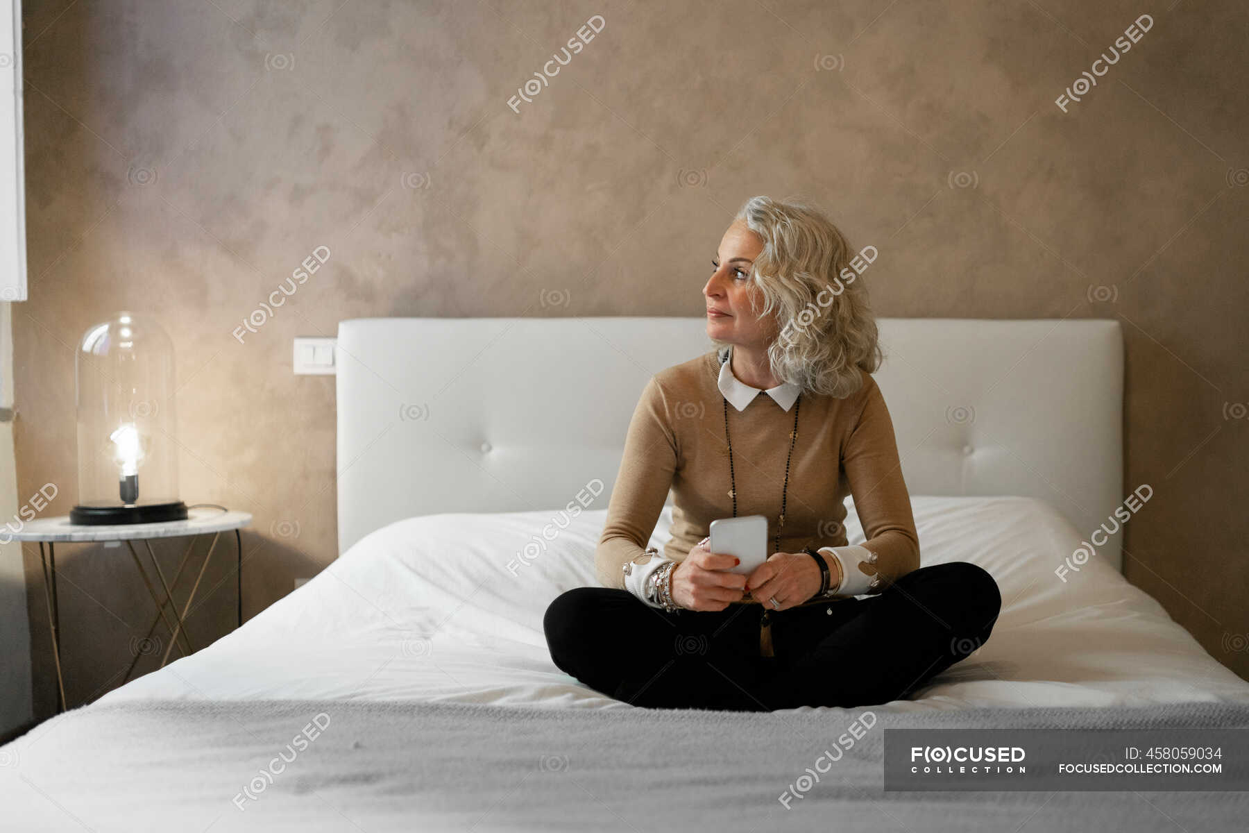 Зрелая женщина на большой кровати