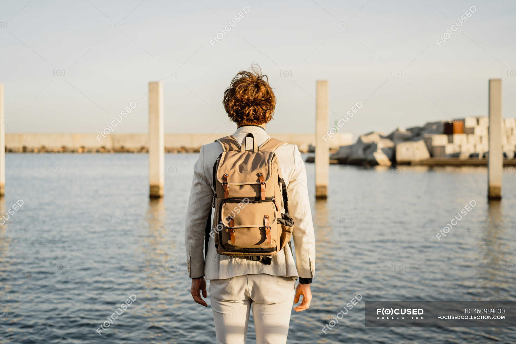 Back view of businessman with backpack looking at distance, Barcelona