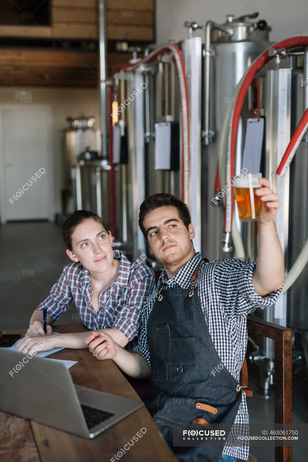 Young entrepreneurs working at a brewery testing beer — judging, job