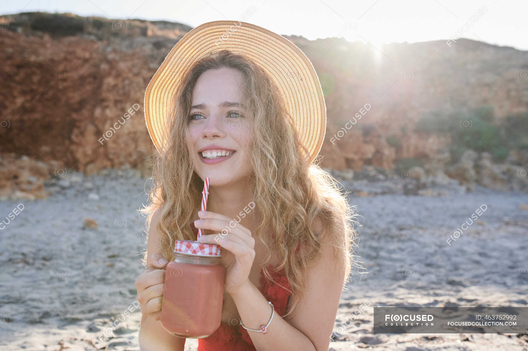 Happy young woman with a smoothie on the beach — attractive, red - Stock  Photo | #463752992