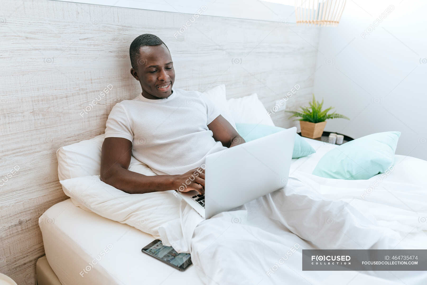 Wolkenkrabber pijp Signaal Young man lying in bed using laptop at home — relaxed, weekend - Stock  Photo | #464735474