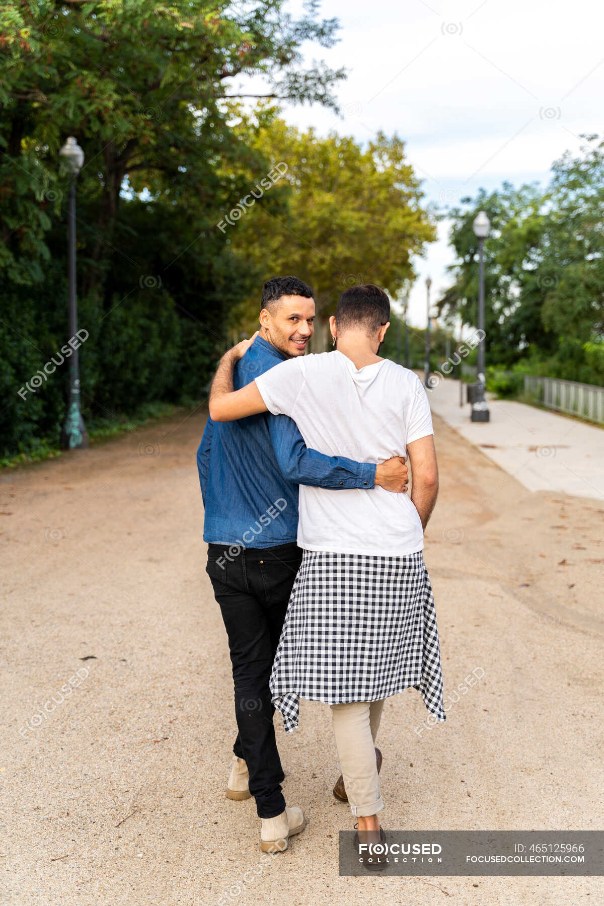 Back View Of Happy Gay Couple Walking Arm In Arm In A Park Barcelona Spain Lovers 30s Stock Photo