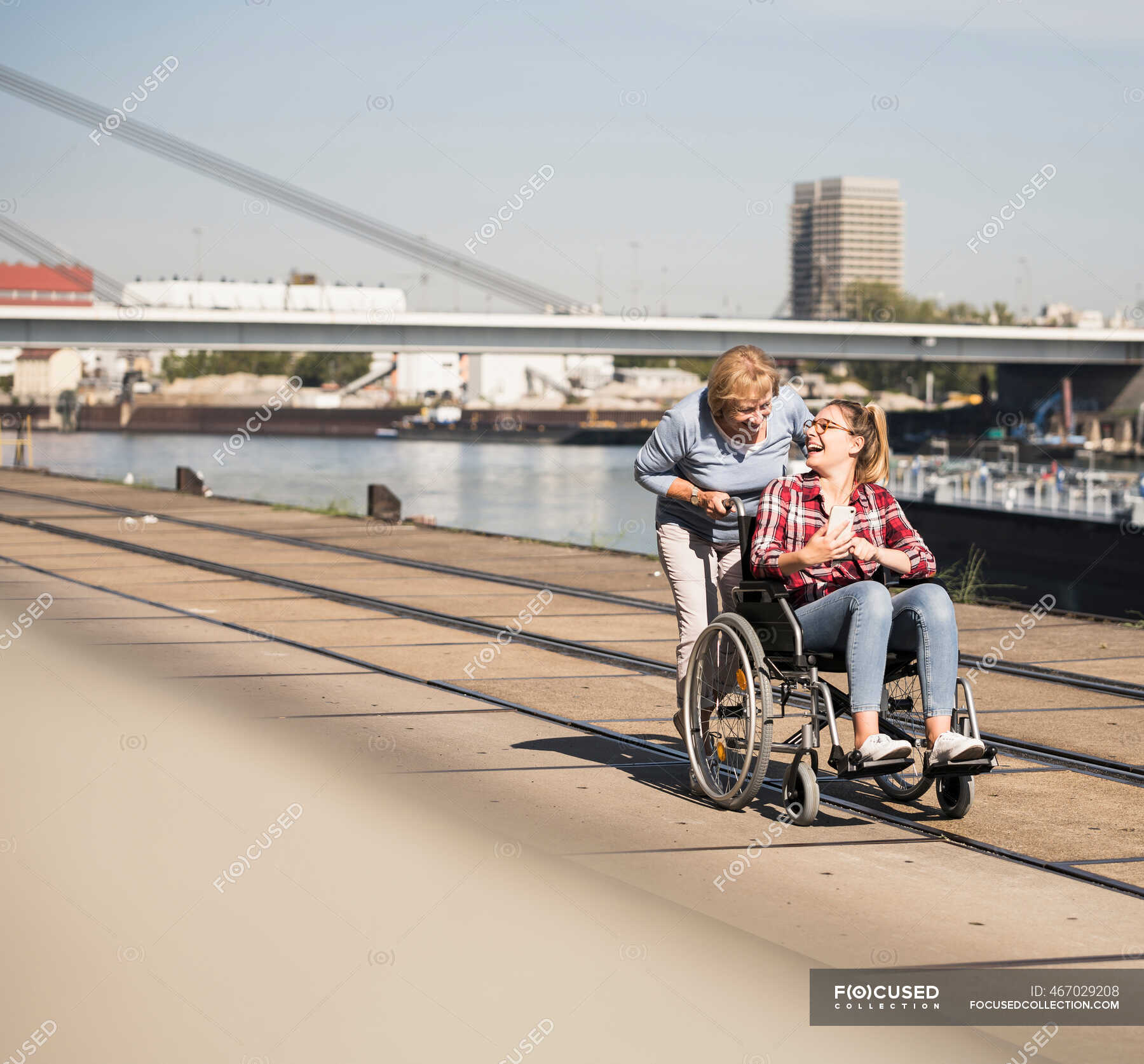 Бабушка с внучкой сидит в инвалидном кресле — Сидя, Оптимистичный - StockPhoto