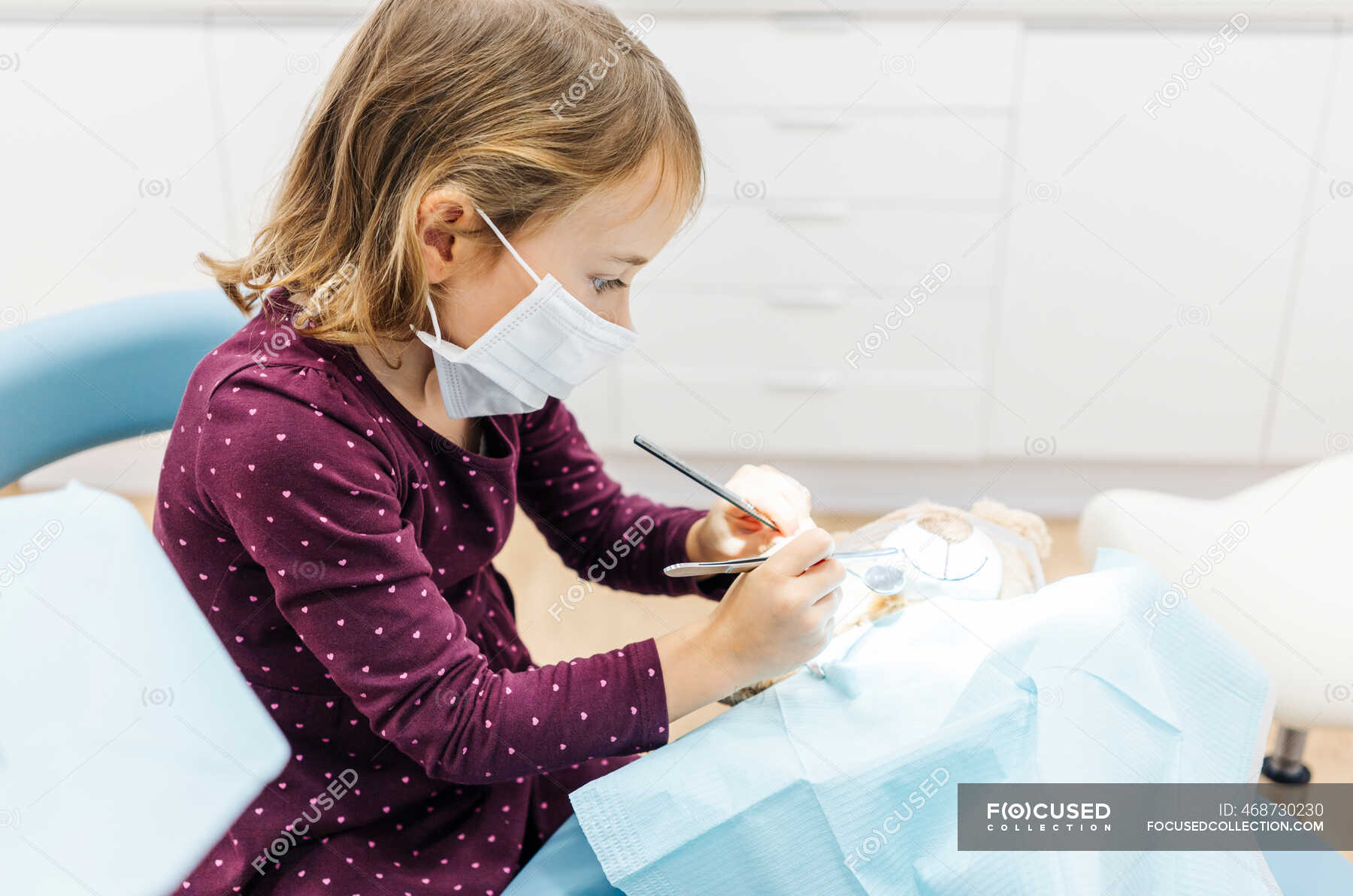 Girl at the dentist examining teddy bear — soft toy, career aspiration ...