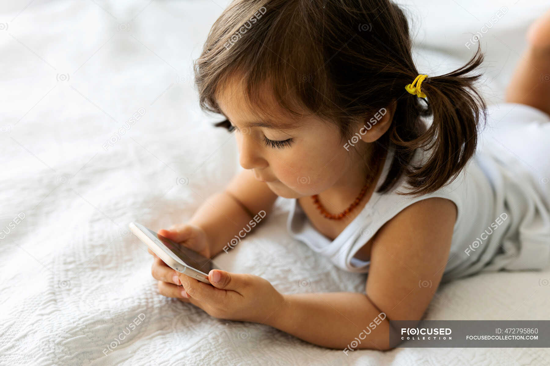 Kleines Mädchen In Unterwäsche Liegt Auf Dem Bett Und Schaut Aufs Smartphone — Spielen Zimmer