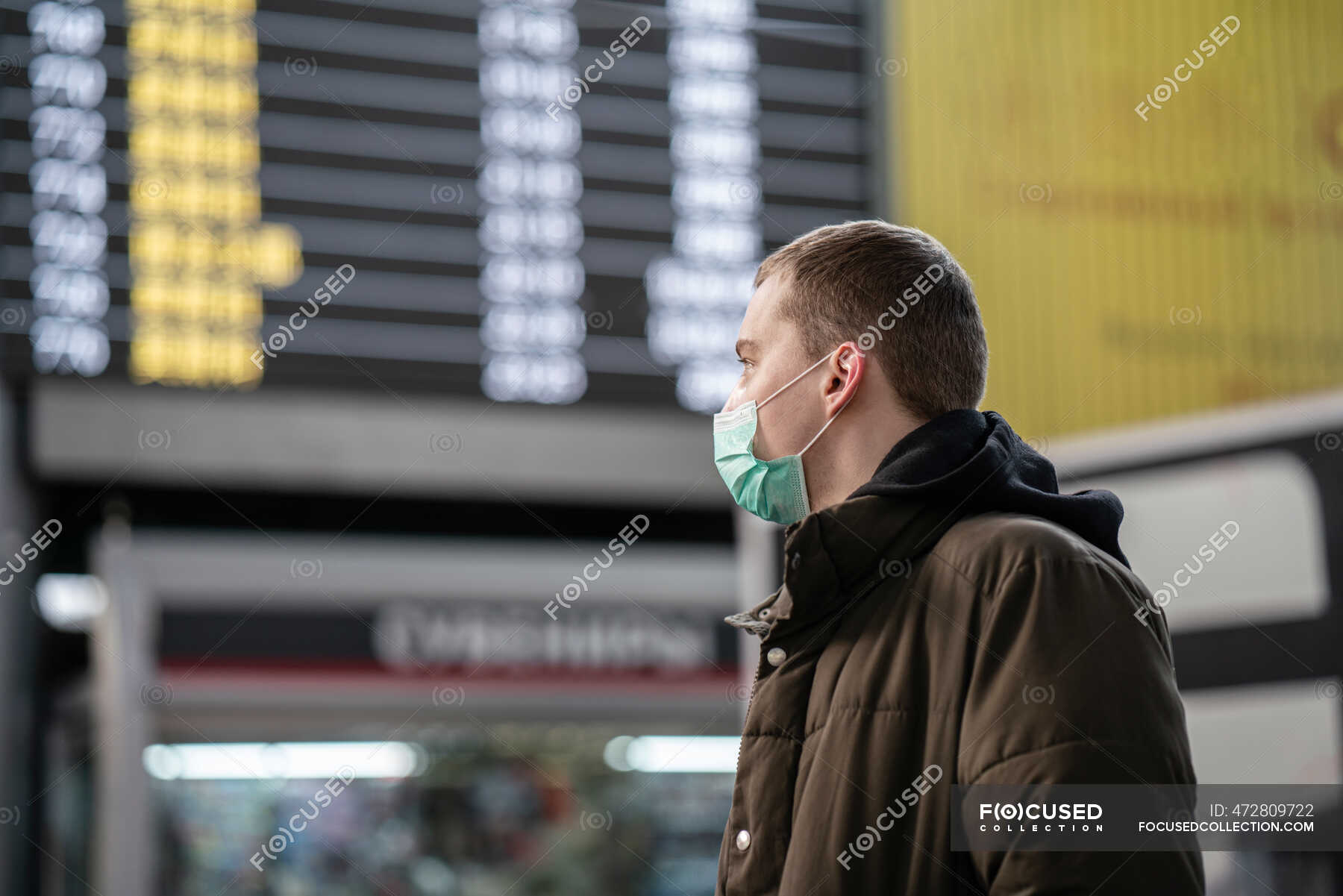 Young man with face mask at train station in the city — one person