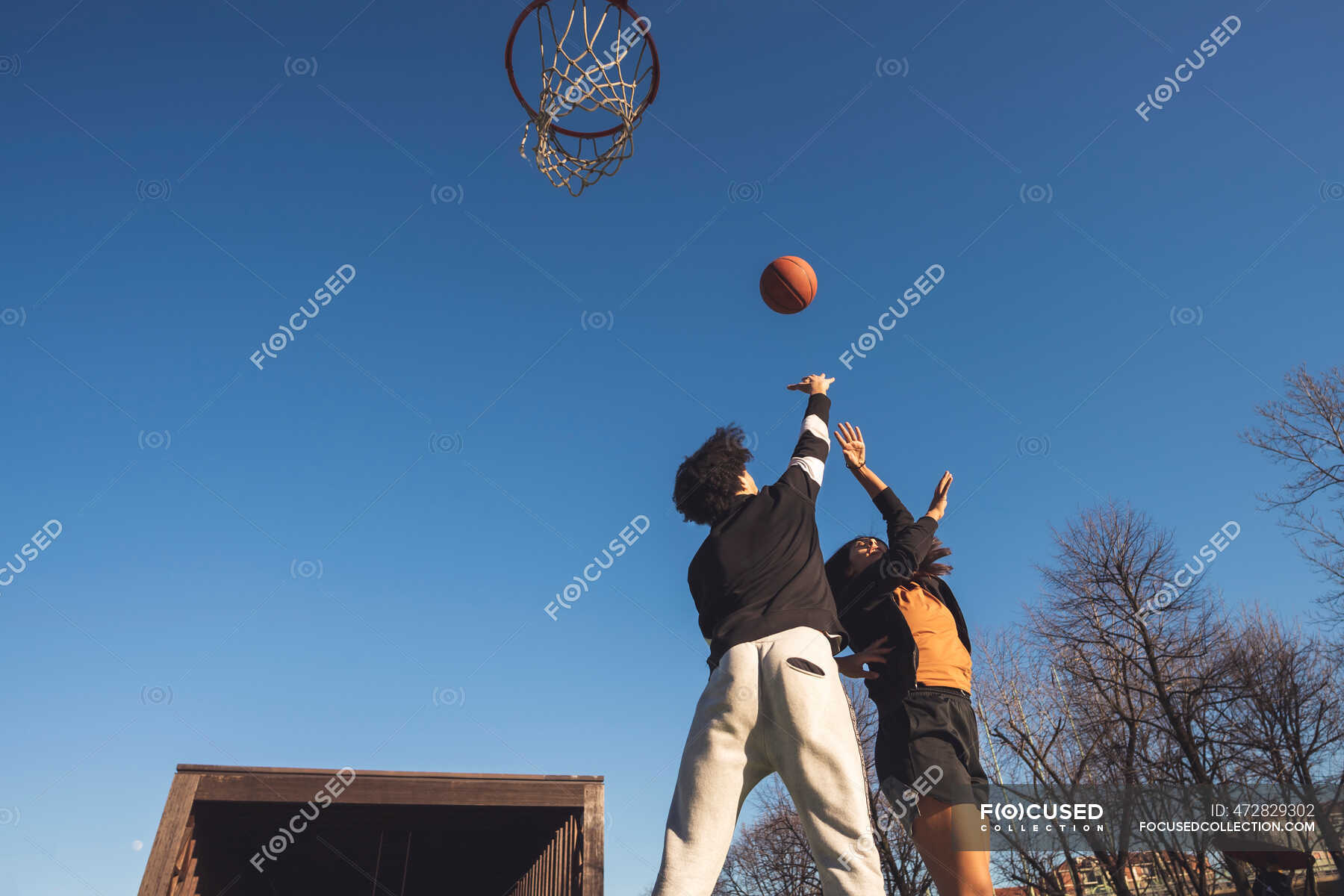 Jovem e mulher jogando basquete na quadra — Duas pessoas