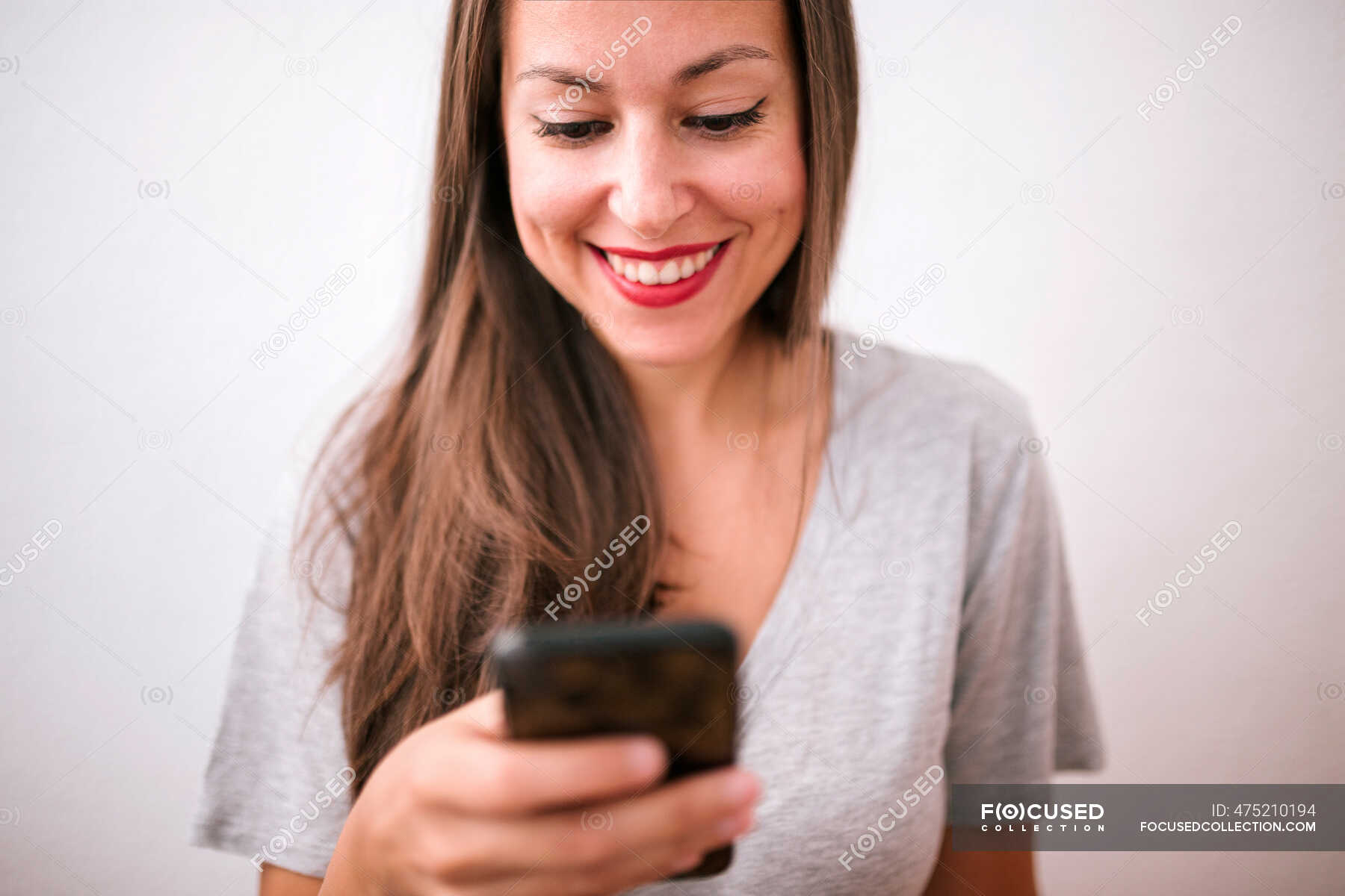 Beautiful Happy Woman Text Messaging Through Smart Phone Against White Background 8563