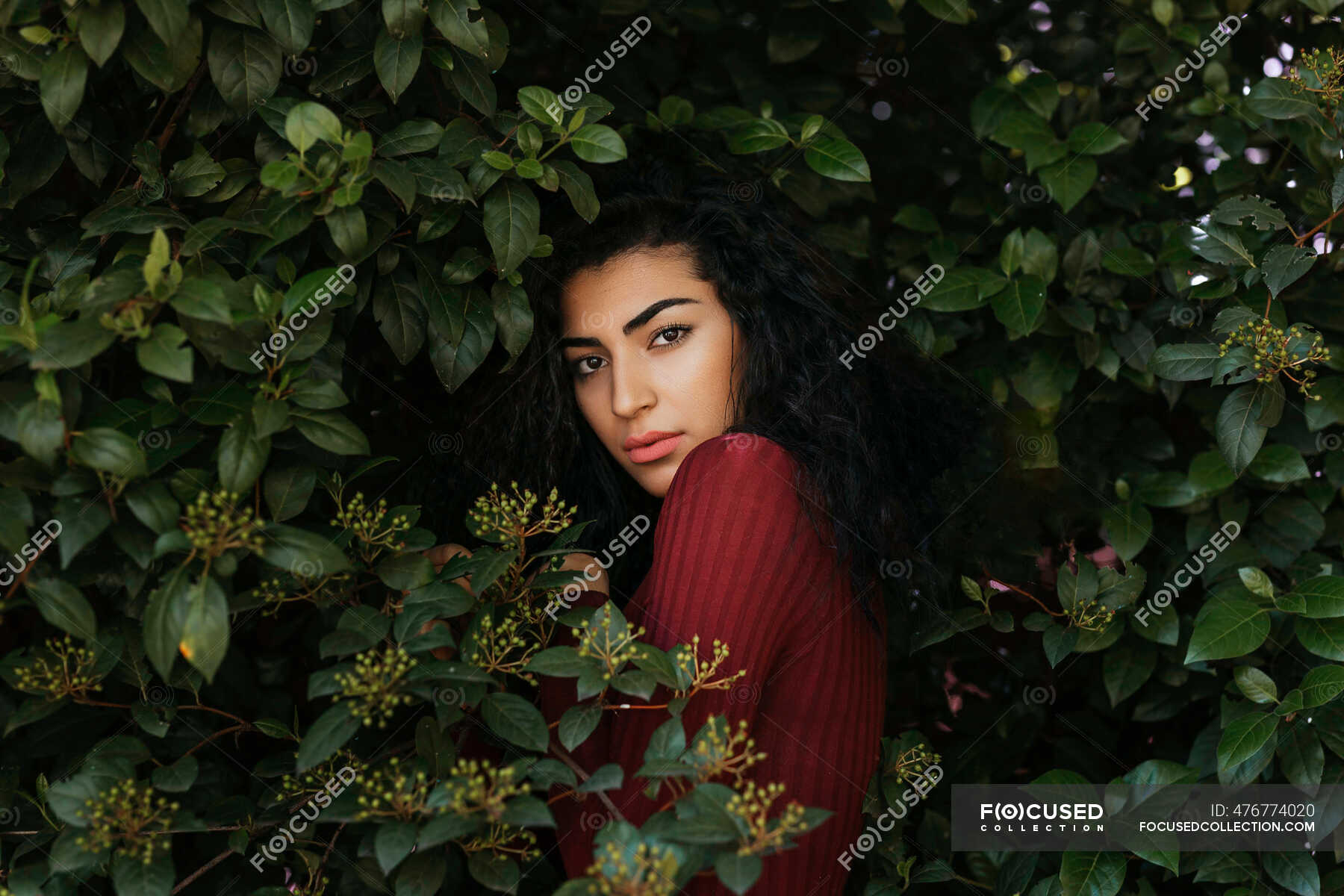 Portrait of young black-haired woman between leaves — granada, people ...