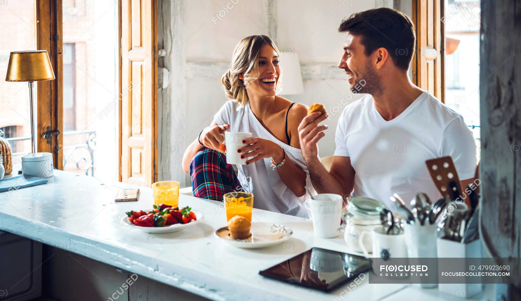 Жена на кухонном столе. Совместный завтрак. Мужчина и женщина завтракают. Завтрак вдвоем. Фотосессия на кухне.