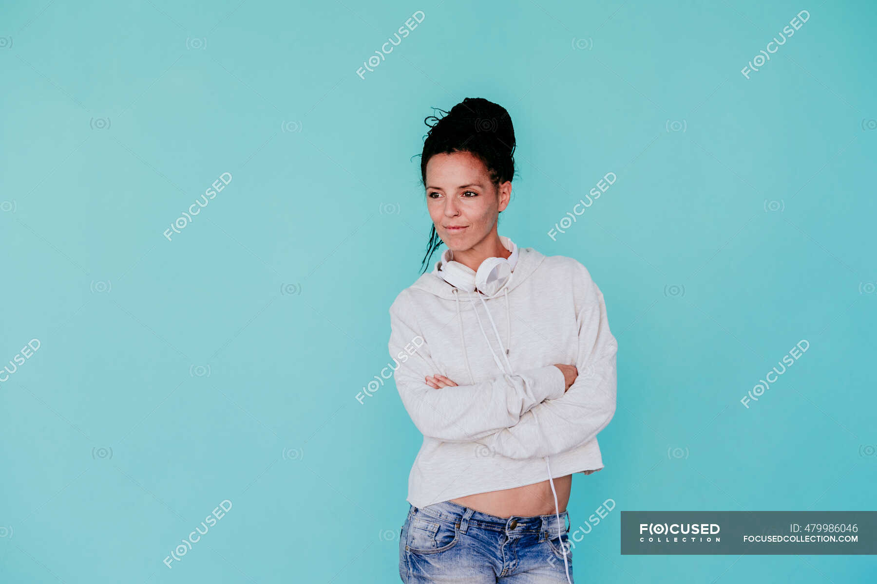 beautiful-woman-with-arms-crossed-looking-away-while-standing-against