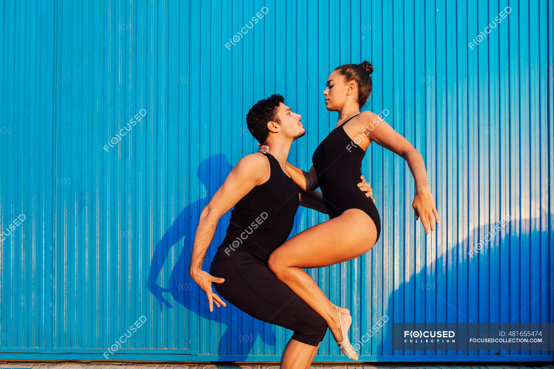 Professional Gymnast Couple Doing Balancing Pose By Blue Corrugated