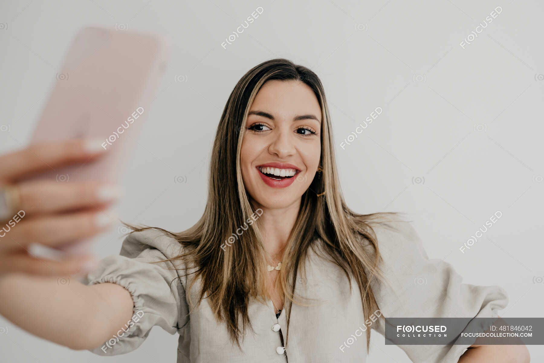 Smiling Woman Taking Selfie Through Mobile Phone Against White Background — Beautiful Woman 