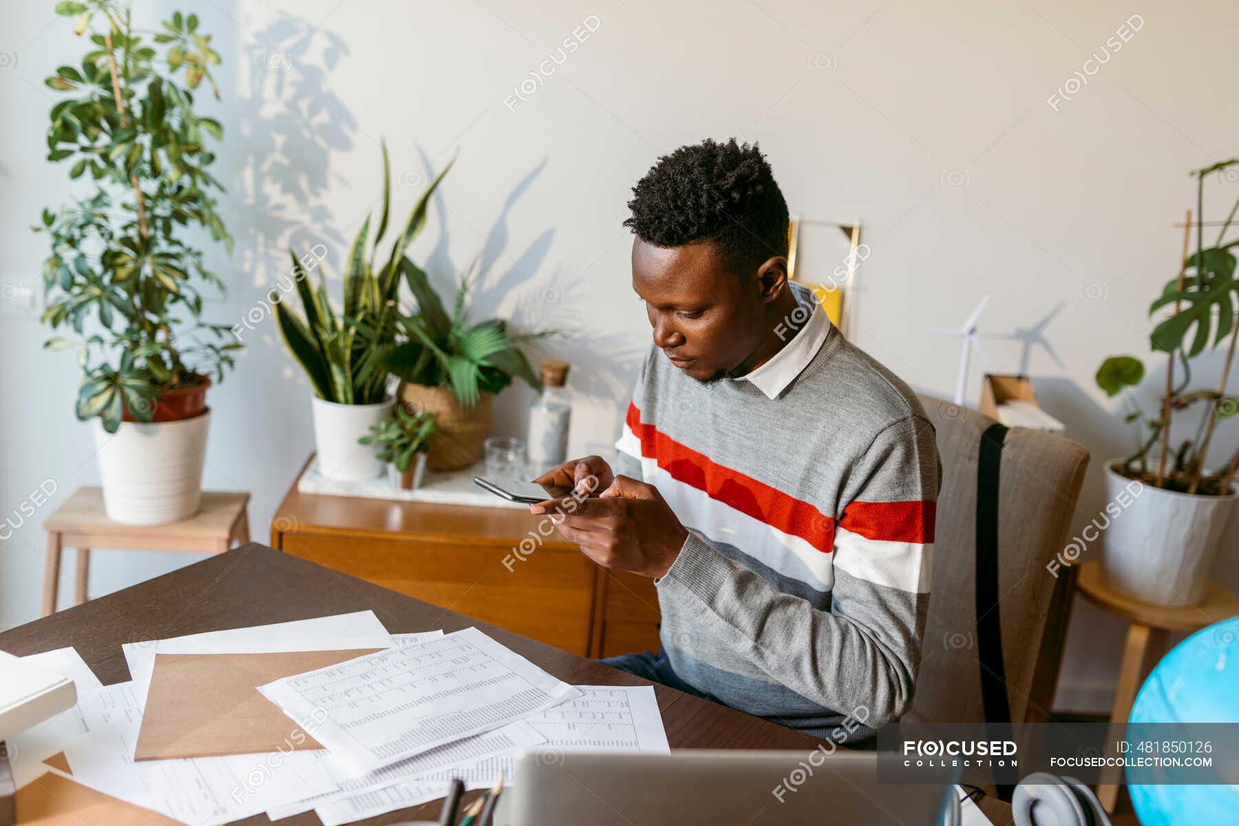 Male financial advisor taking photo of account document on desk at home