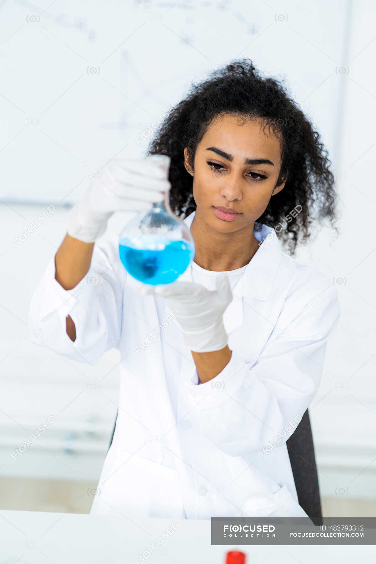 Young Female Researcher Analyzing Liquid In Flask In Laboratory — Healthcare Worker Laboratory 