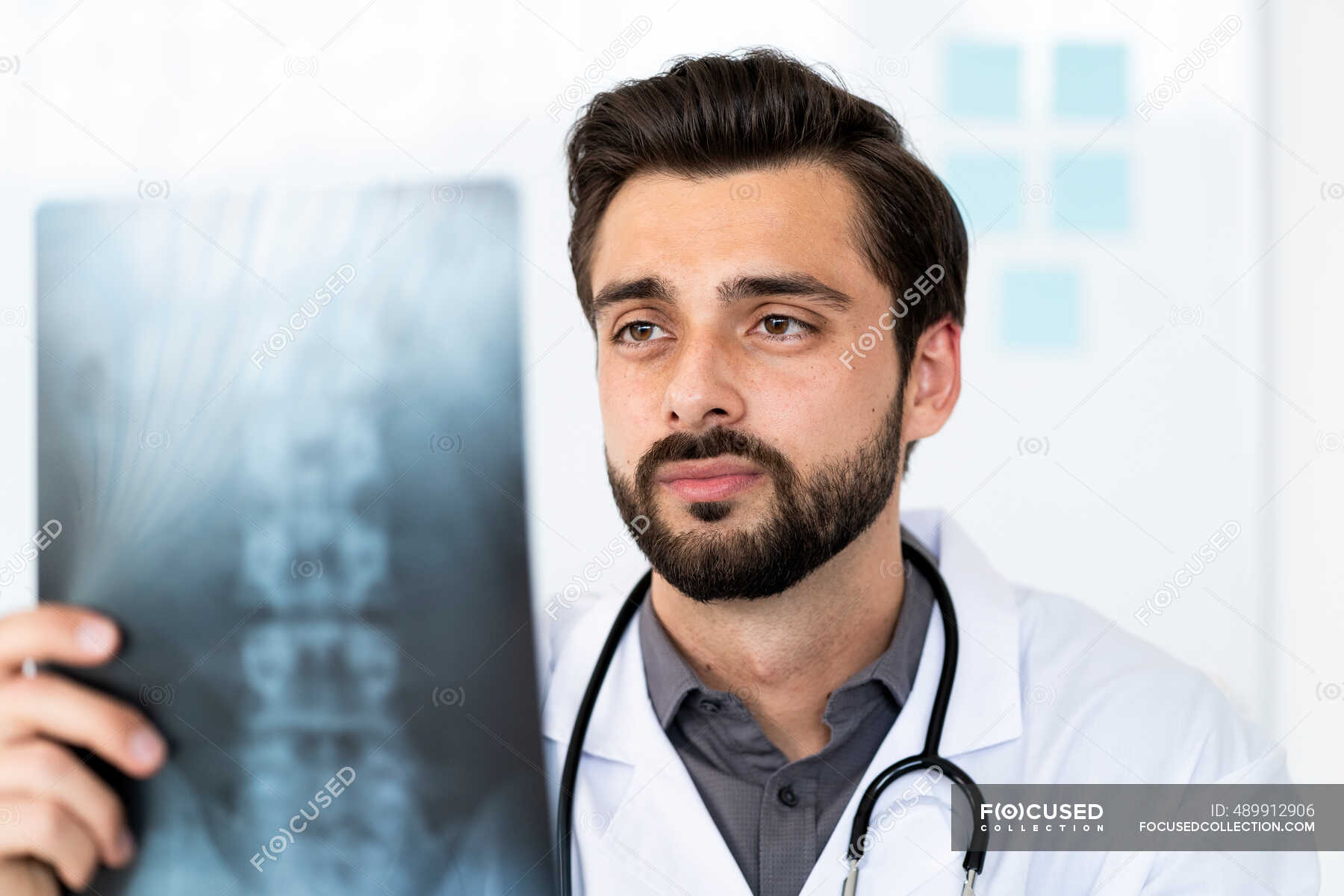 Handsome male healthcare worker analyzing Xray in hospital