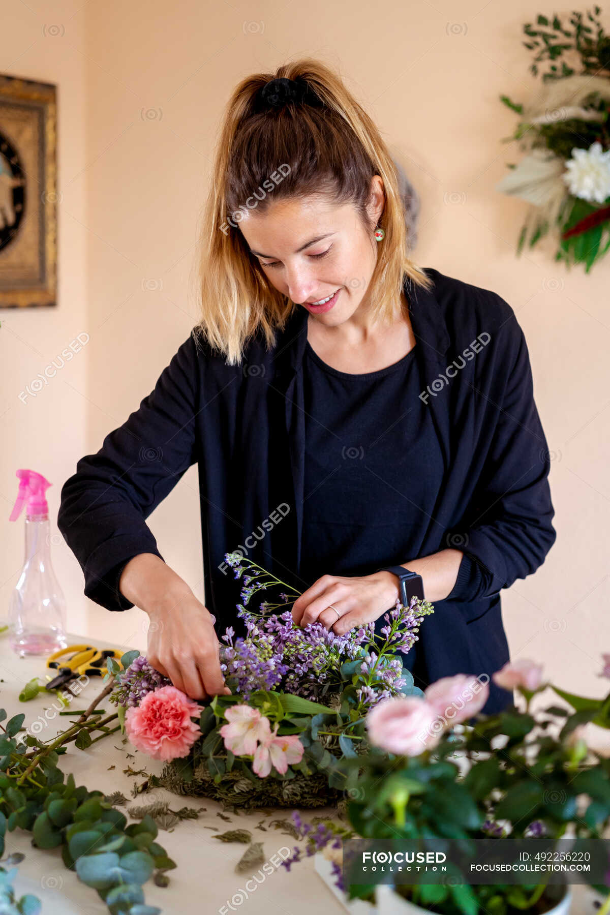 Female florist making flower arrangement at workshop — working ...