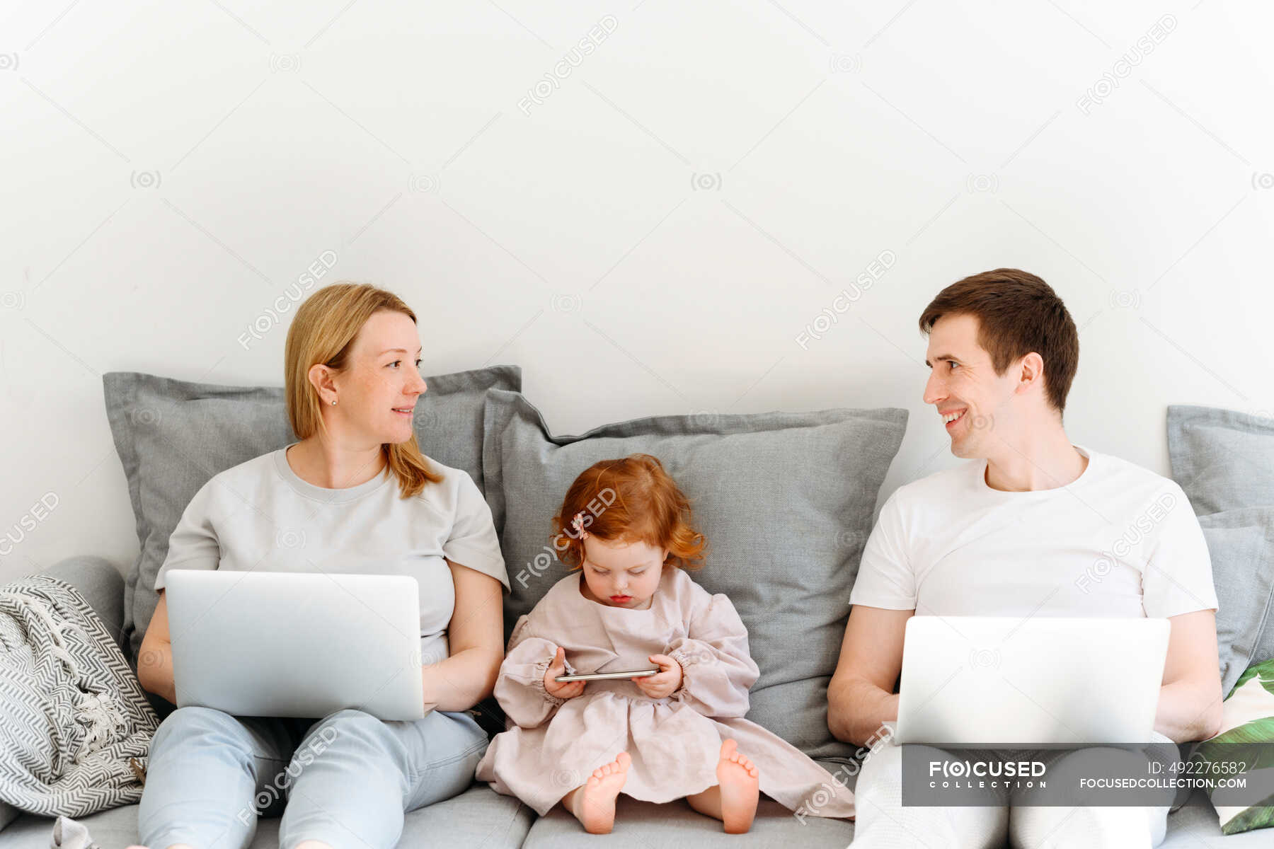 Семья на диване с ноутбуком