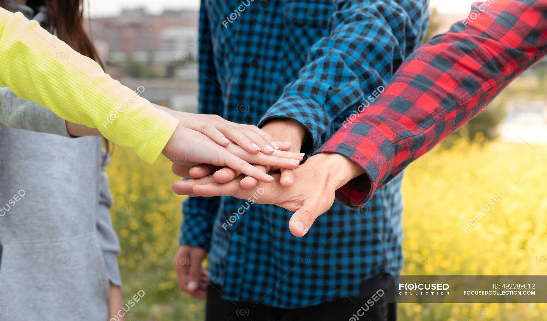 male-and-female-friends-stacking-hands-unity-group-stock-photo