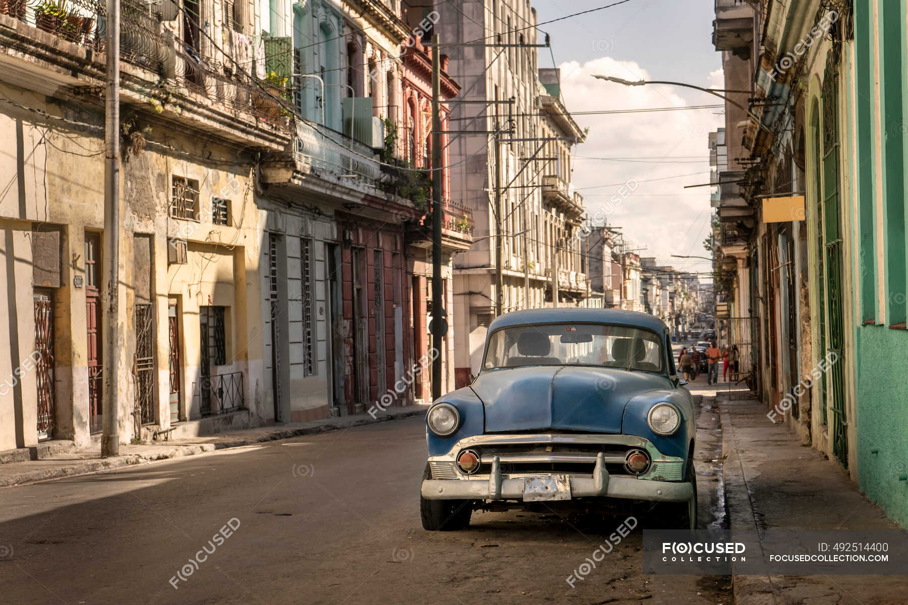 Vintage car parked by residential building in old city — typical, sky