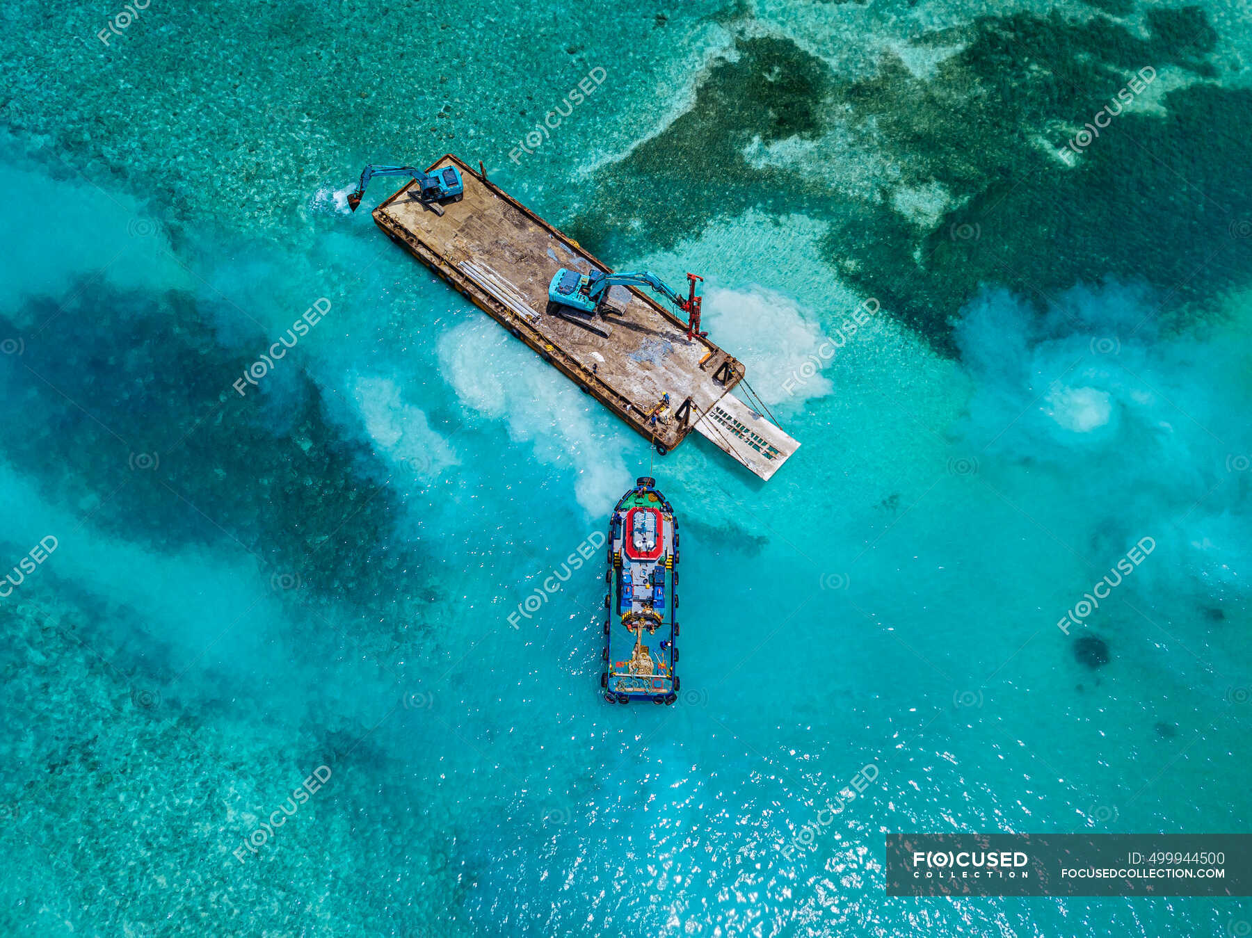 aerial-view-of-earth-movers-handling-poles-on-floating-platform-in-male