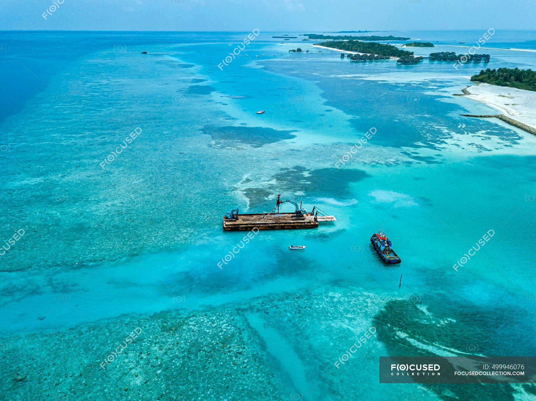 aerial-view-of-earth-movers-handling-poles-on-floating-platform-in-male