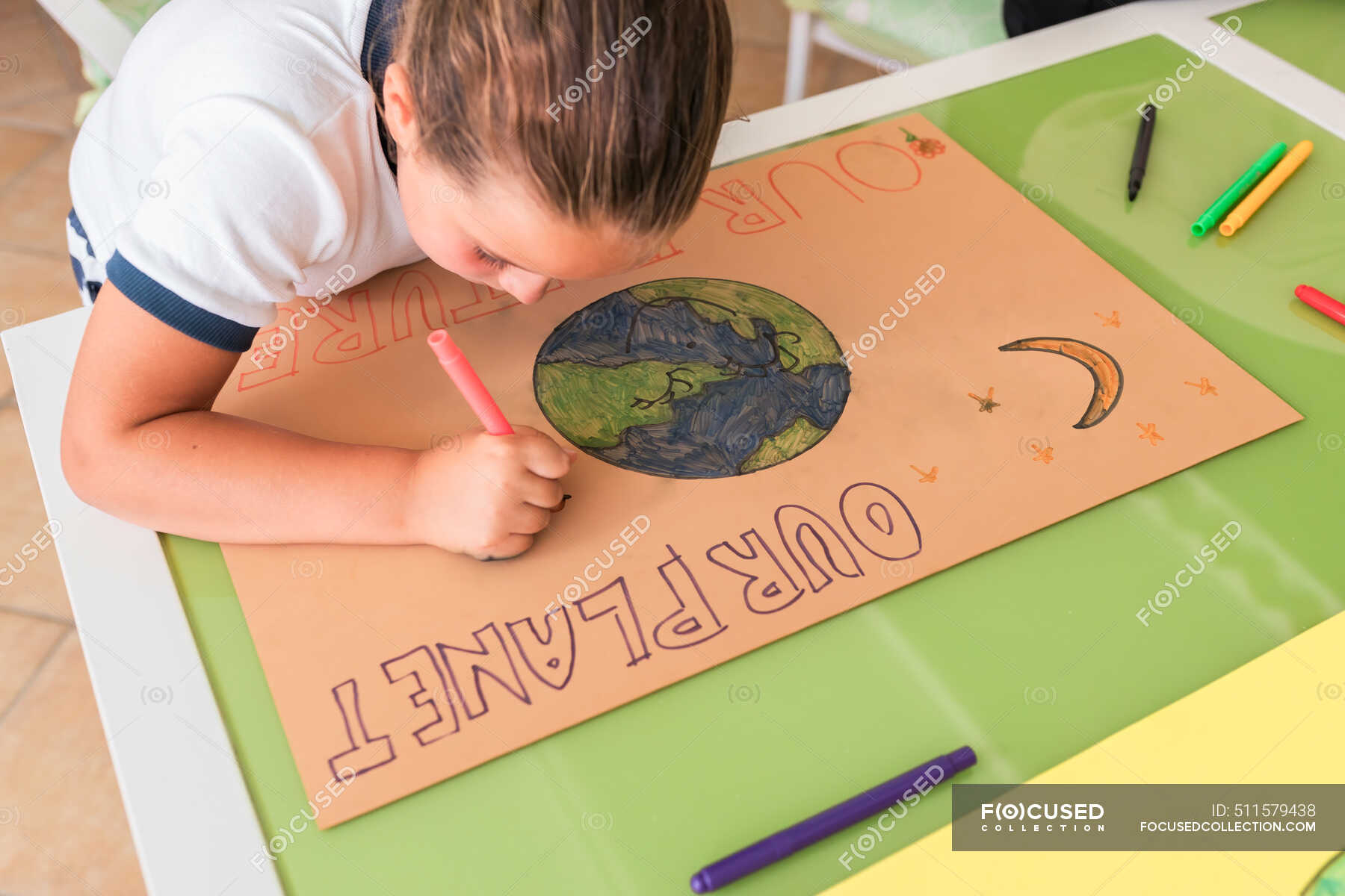 Girl drawing sun on cardboard paper at home stock photo