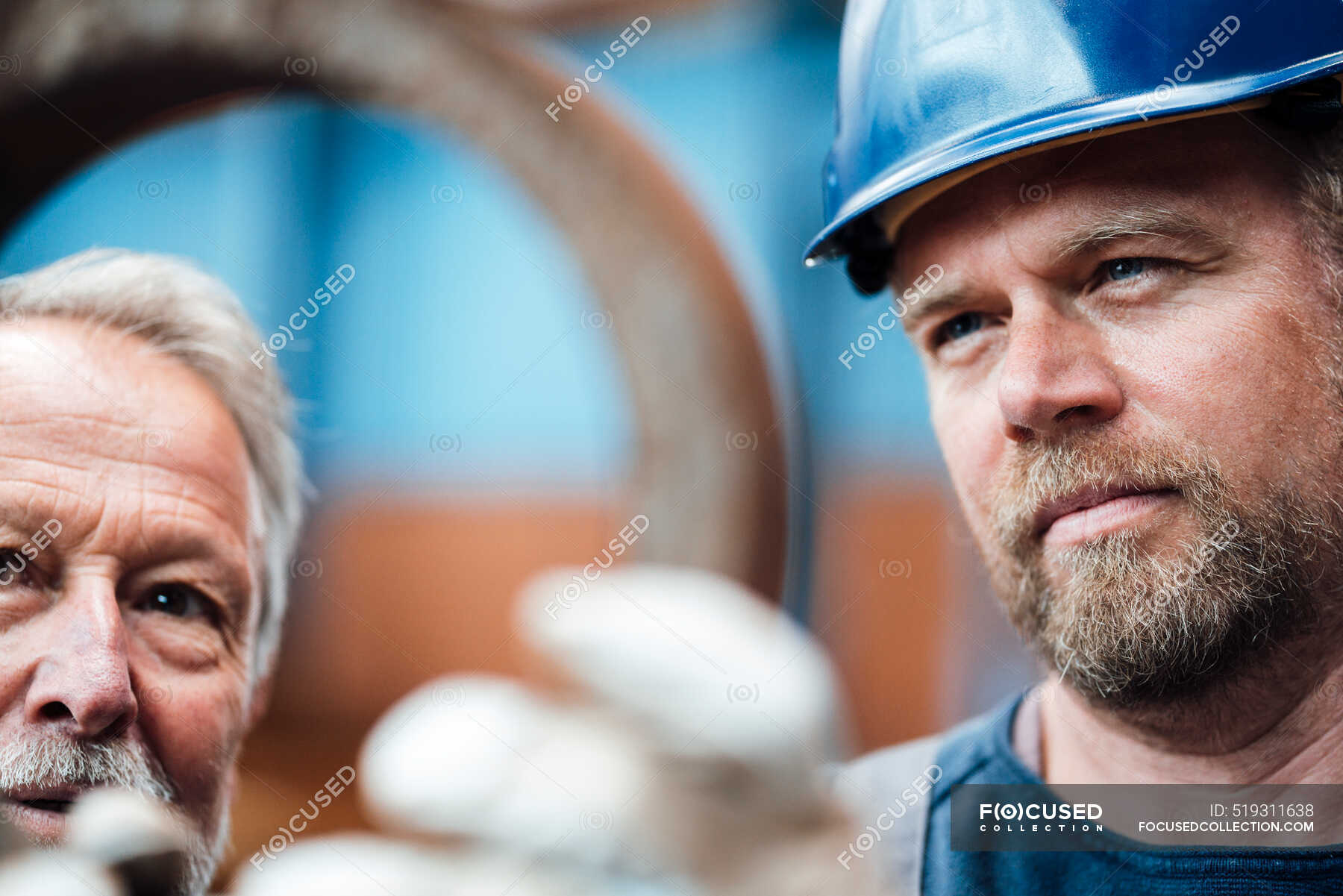 male-warehouse-worker-checking-equipment-with-manager-in-industry