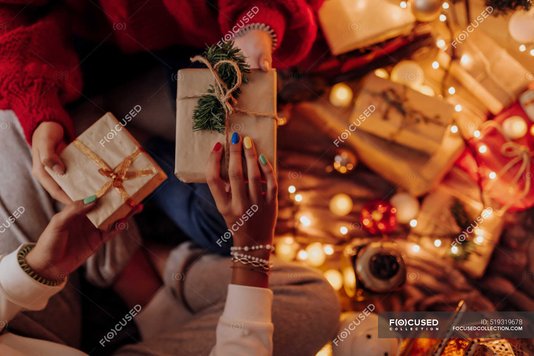 Female friends giving gifts to each other in room Vector Image