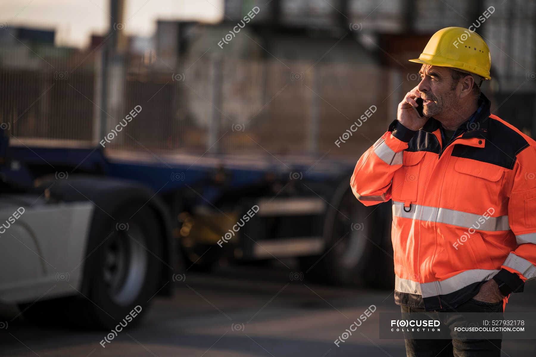 male-dock-worker-with-hands-in-pockets-standing-at-industry-hard-hat