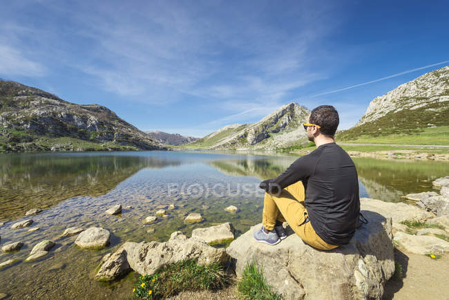 Человек, сидящий на озере Ковадонга — стоковое фото