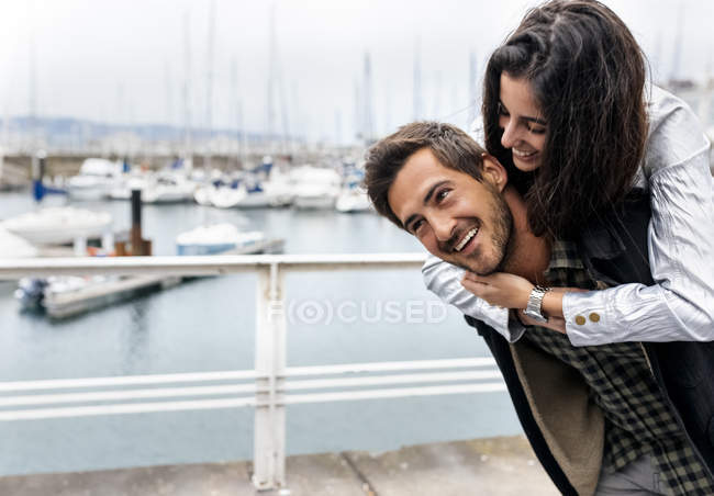 Пара piggybacking в marina — стокове фото