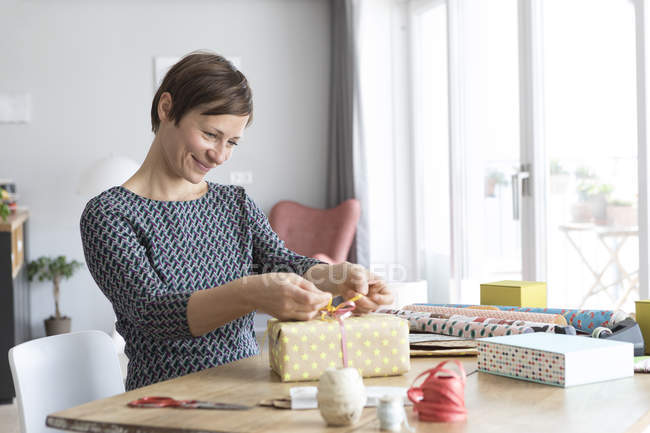 Woman wrapping gifts — Stock Photo