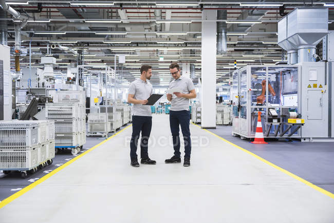 Männer stehen und reden in Fabrik — Stockfoto