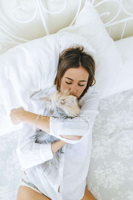Mulher abraçando e beijando Yorkshire Terrier — Fotografia de Stock