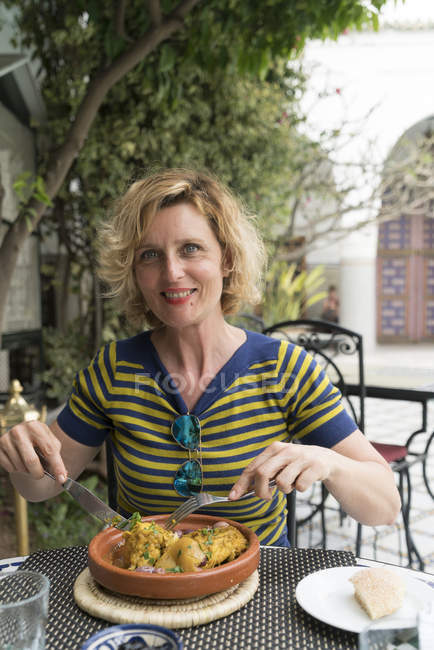 Donna sorridente che mangia nel ristorante — Foto stock