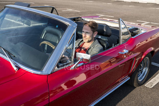 Hombre sentado en coche deportivo - foto de stock
