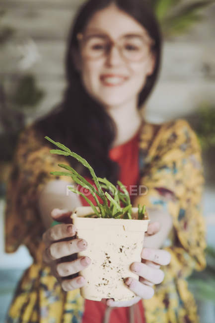 Woman holding freshly potted cactus — Stock Photo